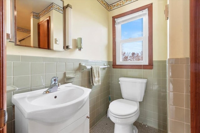 bathroom with tile patterned floors, sink, toilet, and tile walls