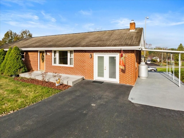 back of property featuring french doors and a carport