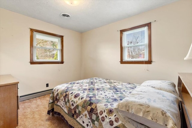 carpeted bedroom with a textured ceiling and a baseboard radiator