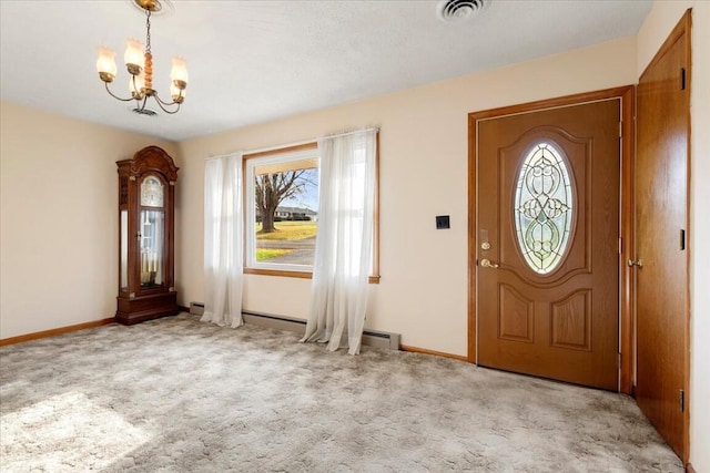 carpeted entrance foyer featuring a notable chandelier