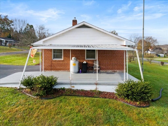 rear view of house featuring a patio area and a yard