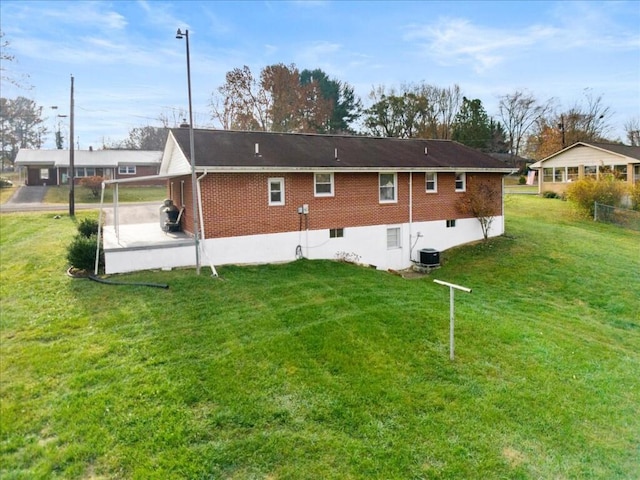 rear view of house with a yard and cooling unit