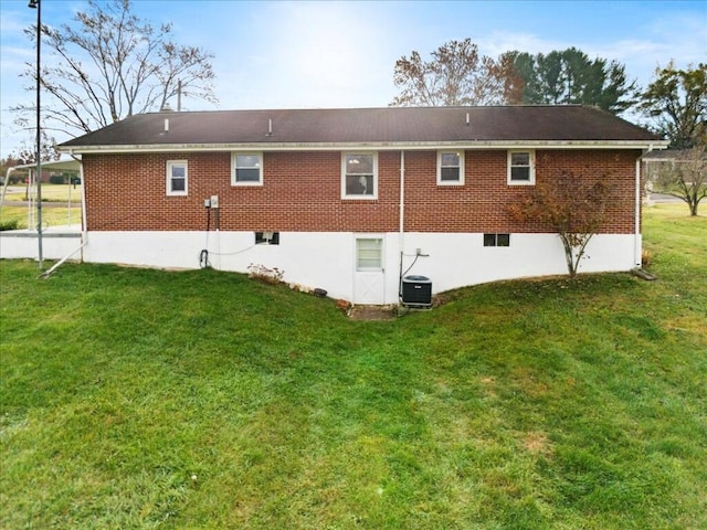 rear view of property featuring a yard and central AC