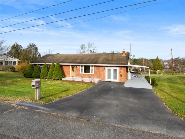 ranch-style home with french doors, a front lawn, and a carport