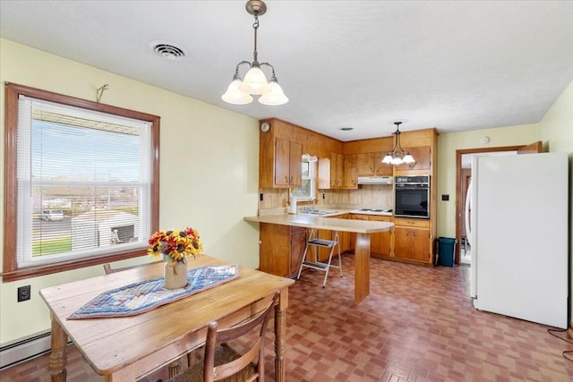 dining room with sink, a baseboard radiator, and an inviting chandelier