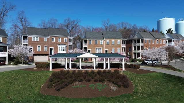 rear view of house featuring a gazebo and a yard