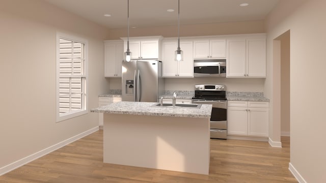 kitchen featuring a center island with sink, a sink, stainless steel appliances, light wood-style floors, and white cabinetry