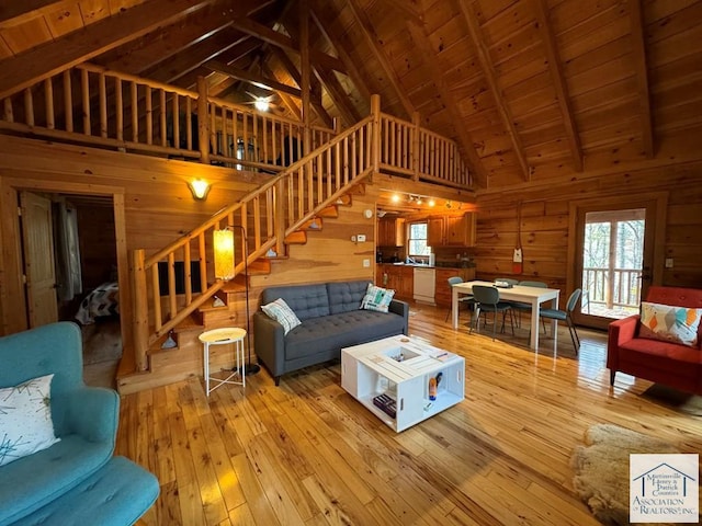 living room featuring high vaulted ceiling, light wood-type flooring, wooden walls, and wood ceiling