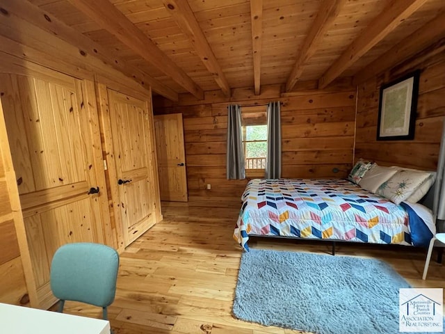 bedroom with beamed ceiling, wooden walls, light wood-type flooring, and wood ceiling