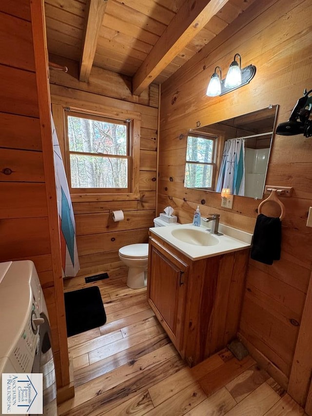 bathroom featuring wood walls, a wealth of natural light, beamed ceiling, and hardwood / wood-style flooring