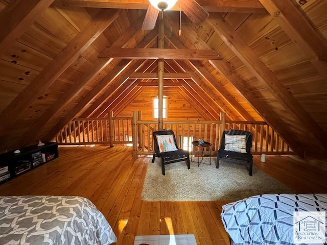 unfurnished bedroom with lofted ceiling with beams, hardwood / wood-style flooring, and wooden ceiling