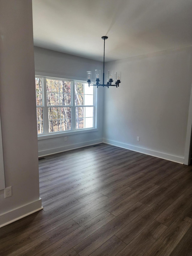 unfurnished dining area featuring an inviting chandelier and dark hardwood / wood-style flooring