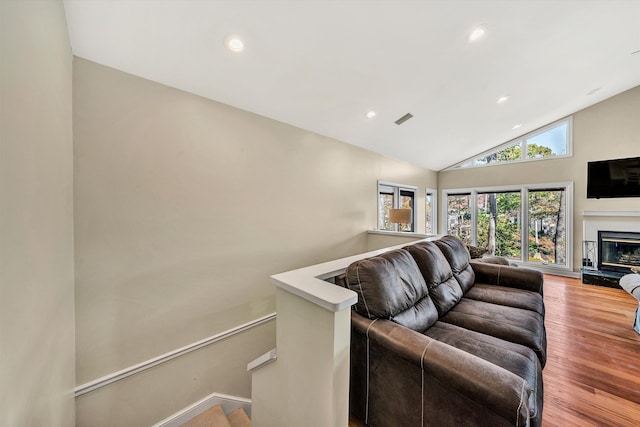 living room featuring light wood-type flooring and vaulted ceiling