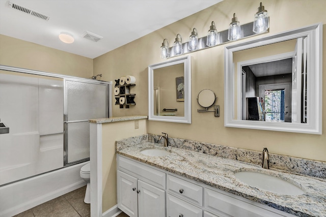 full bathroom with toilet, vanity, tile patterned flooring, and shower / bath combination with glass door