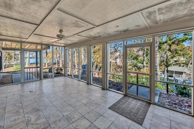 unfurnished sunroom with ceiling fan