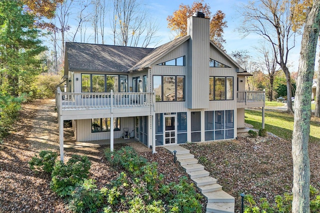 rear view of property with a sunroom and a deck