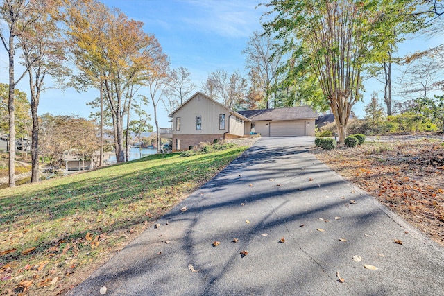 view of front of house featuring a front yard, a water view, and a garage