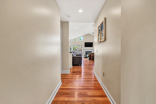 hall featuring lofted ceiling and hardwood / wood-style flooring