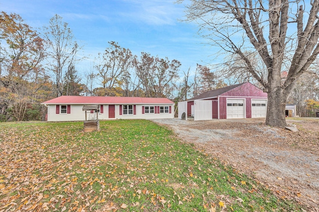 single story home featuring a garage, an outbuilding, and a front lawn