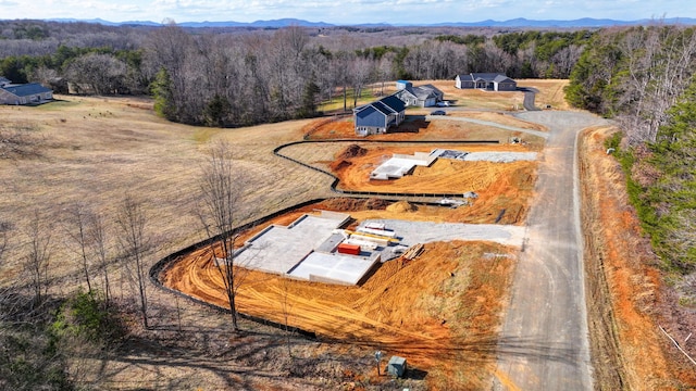 drone / aerial view featuring a mountain view and a wooded view