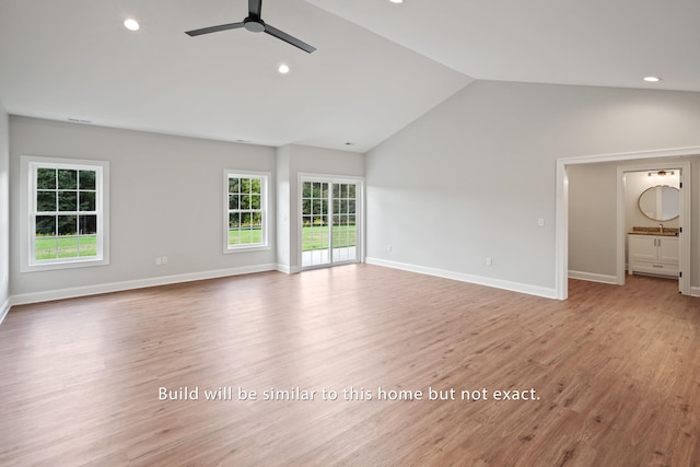 unfurnished living room featuring vaulted ceiling, a ceiling fan, light wood-style flooring, and baseboards