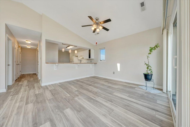 unfurnished living room with lofted ceiling, ceiling fan, and light hardwood / wood-style flooring