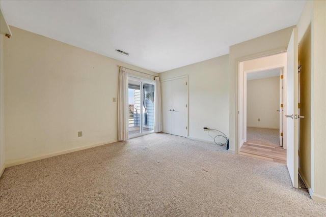 empty room featuring baseboards, visible vents, and carpet flooring