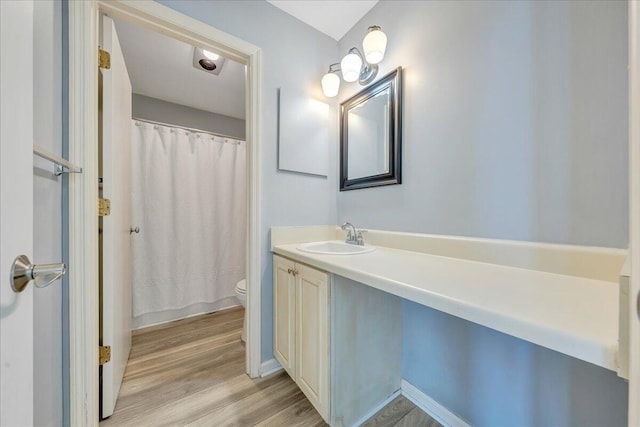 full bathroom with toilet, wood finished floors, and vanity