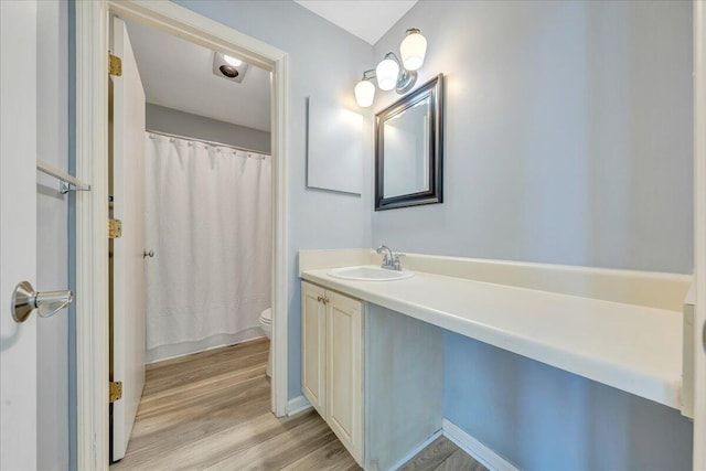 bathroom featuring vanity, hardwood / wood-style floors, toilet, and a shower with shower curtain