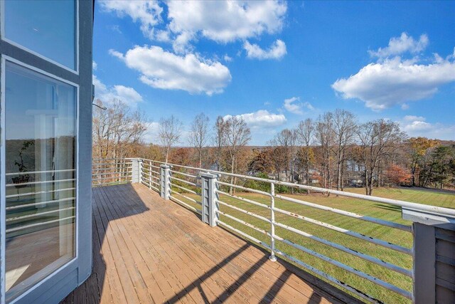 wooden terrace with a lawn