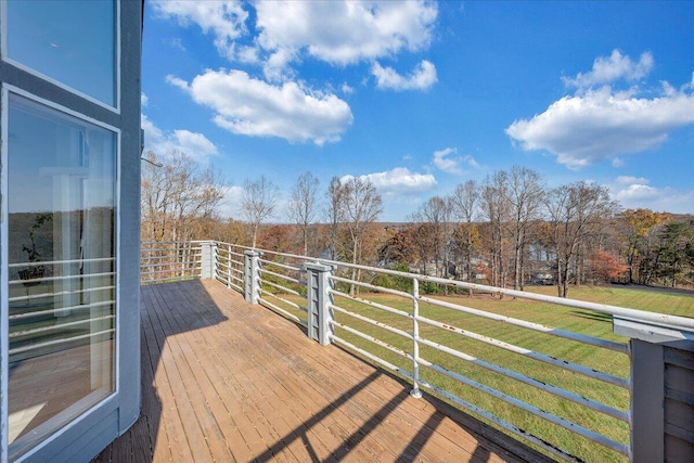 deck with a rural view and a yard