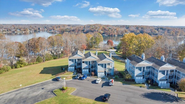 birds eye view of property with a water view and a wooded view