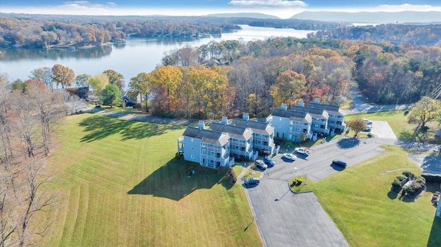 aerial view with a water view and a wooded view