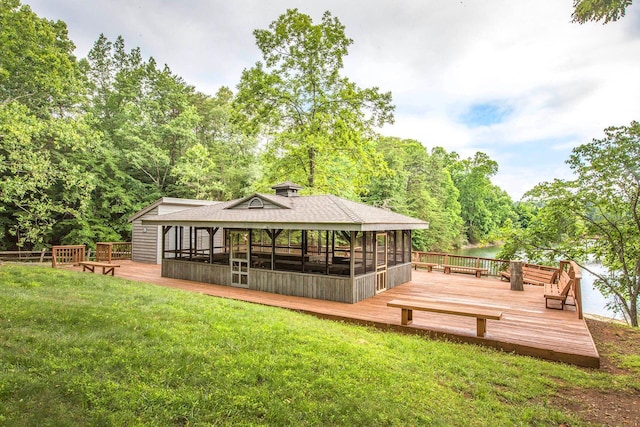 rear view of property with a shingled roof, a lawn, and a wooden deck