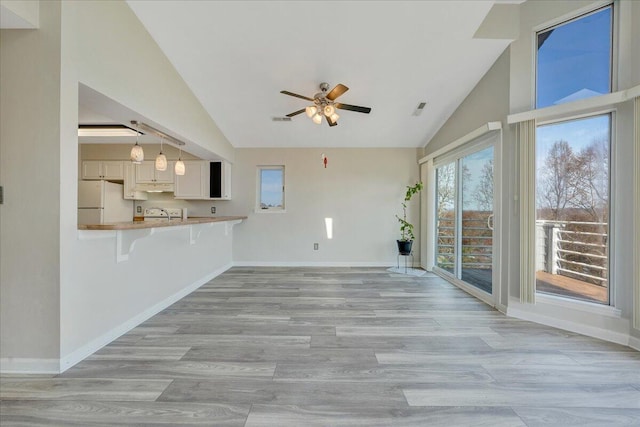 unfurnished living room with light wood-type flooring, visible vents, and baseboards