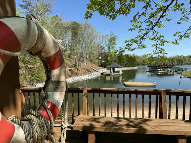 wooden deck with a dock and a water view