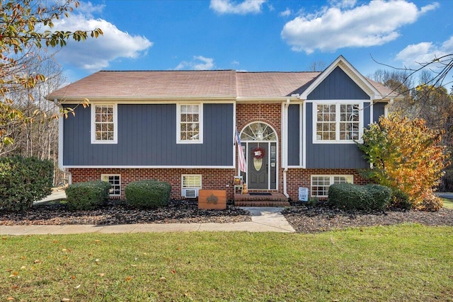 split foyer home featuring brick siding and a front lawn