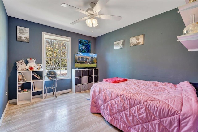 bedroom featuring ceiling fan, wood finished floors, visible vents, and baseboards