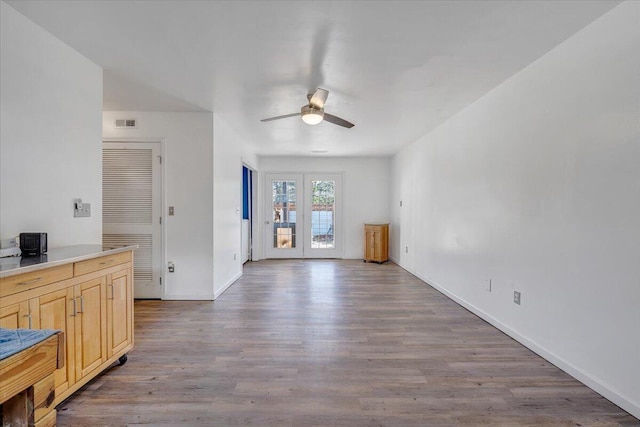 unfurnished living room with visible vents, ceiling fan, baseboards, and wood finished floors