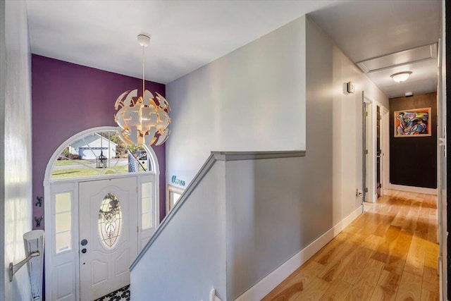 entrance foyer with baseboards, a chandelier, and light wood-style floors