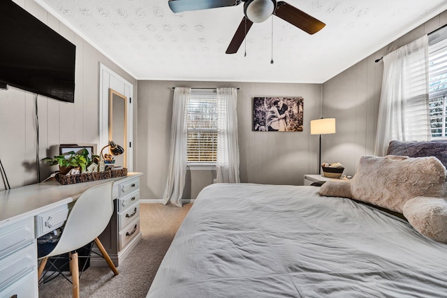 carpeted bedroom featuring multiple windows and ceiling fan