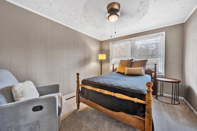 bedroom with ceiling fan, a textured ceiling, wooden walls, and carpet