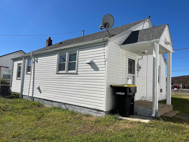 view of side of property featuring central air condition unit and a lawn