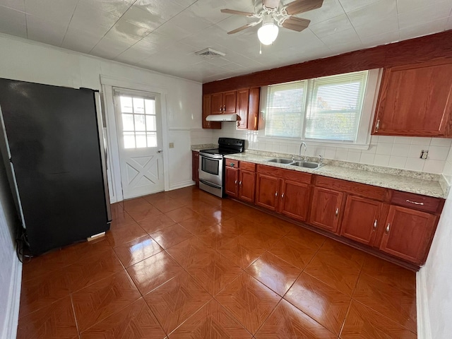 kitchen featuring sink, ceiling fan, stainless steel range with electric stovetop, fridge, and decorative backsplash