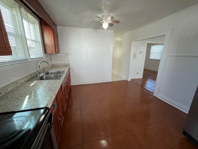 kitchen featuring decorative backsplash, a wealth of natural light, sink, and black / electric stove