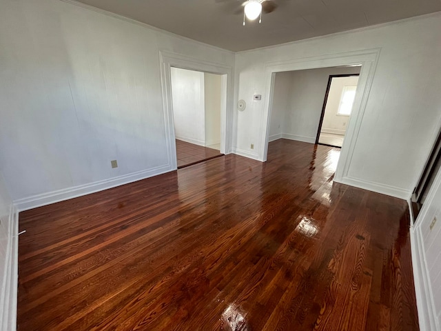 unfurnished room featuring dark wood-type flooring, ceiling fan, and crown molding