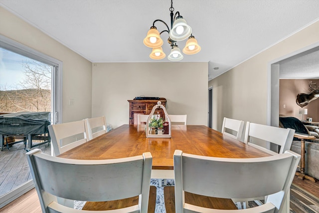 dining room with light wood finished floors and a chandelier