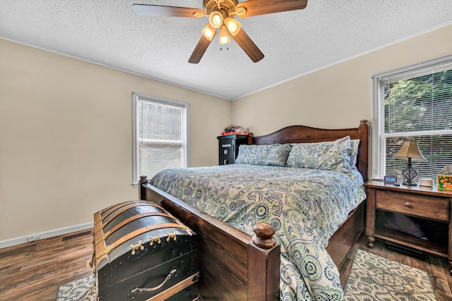 bedroom featuring wood finished floors, baseboards, visible vents, ceiling fan, and a textured ceiling