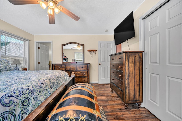 bedroom featuring a textured ceiling, dark wood-type flooring, a ceiling fan, and ornamental molding