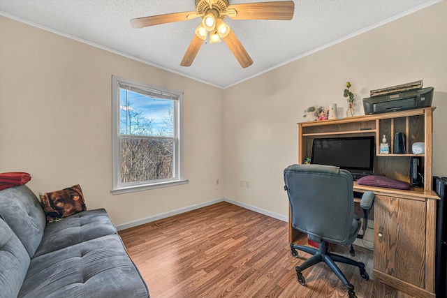 office featuring a ceiling fan, wood finished floors, baseboards, a textured ceiling, and crown molding